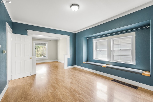 empty room featuring crown molding and light hardwood / wood-style floors