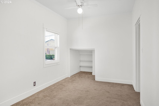 carpeted spare room featuring ceiling fan