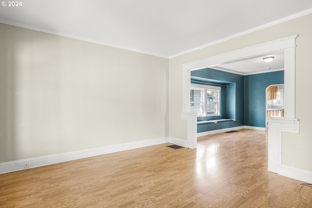 empty room featuring ornamental molding and light hardwood / wood-style floors