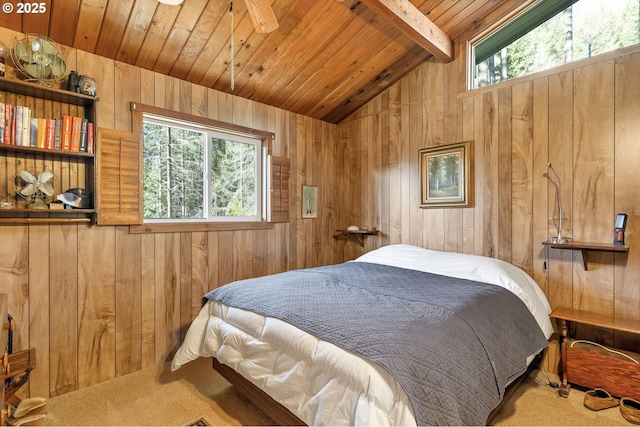 bedroom featuring lofted ceiling with beams, wooden ceiling, wooden walls, carpet flooring, and multiple windows