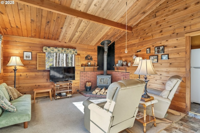 living room featuring vaulted ceiling with beams, a wood stove, carpet flooring, wood walls, and wooden ceiling