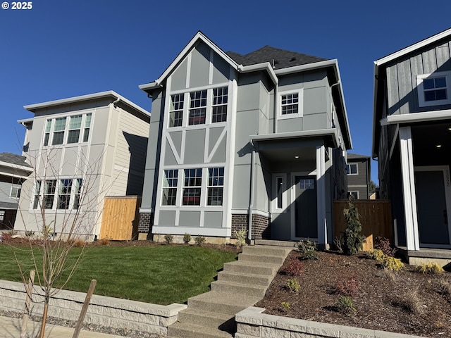 view of front facade featuring a shingled roof, a front lawn, and stucco siding