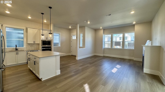 13910 SW 166th Ave, Tigard, OR 97223 - kitchen with appliances with stainless steel finishes, white cabinets, dark wood finished floors, recessed lighting, and backsplash