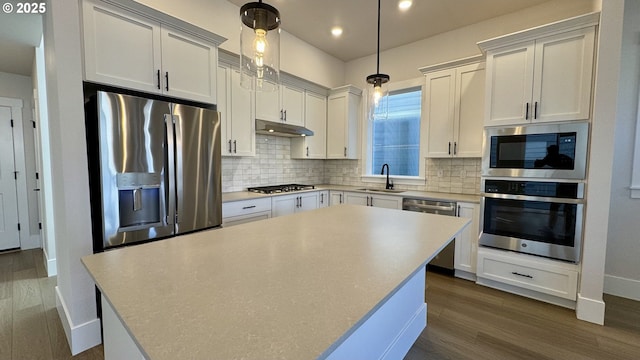 13910 SW 166th Ave, Tigard, OR 97223 - kitchen featuring appliances with stainless steel finishes, under cabinet range hood, a kitchen island, decorative backsplash, and recessed lighting