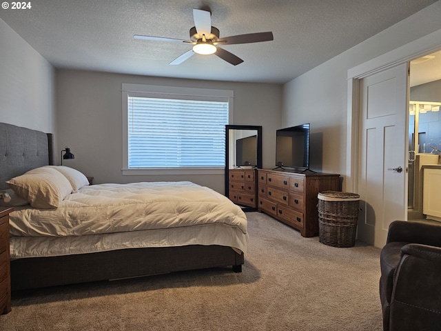 carpeted bedroom featuring ceiling fan, ensuite bathroom, and a textured ceiling