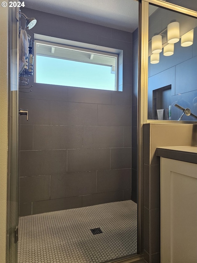 bathroom featuring a shower with door and vanity