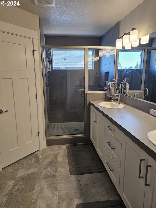 bathroom featuring a wealth of natural light, vanity, and a textured ceiling