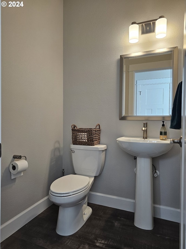 bathroom with hardwood / wood-style flooring and toilet