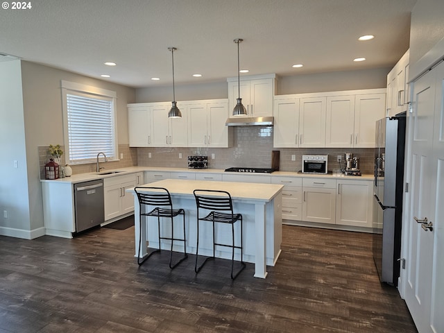 kitchen with sink, white cabinetry, hanging light fixtures, and appliances with stainless steel finishes