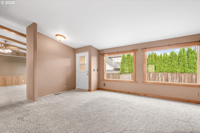 carpeted spare room featuring lofted ceiling and ceiling fan