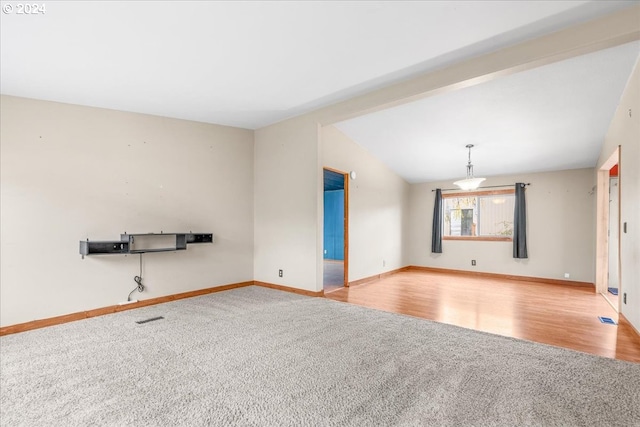 unfurnished room featuring vaulted ceiling with beams and light colored carpet