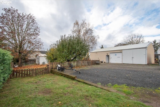 view of yard featuring a garage and an outbuilding