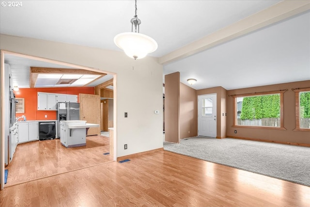 interior space with light wood-type flooring and vaulted ceiling with beams