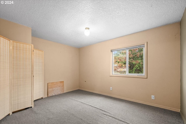 carpeted spare room featuring a textured ceiling