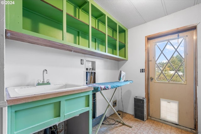 laundry room featuring sink and a textured ceiling