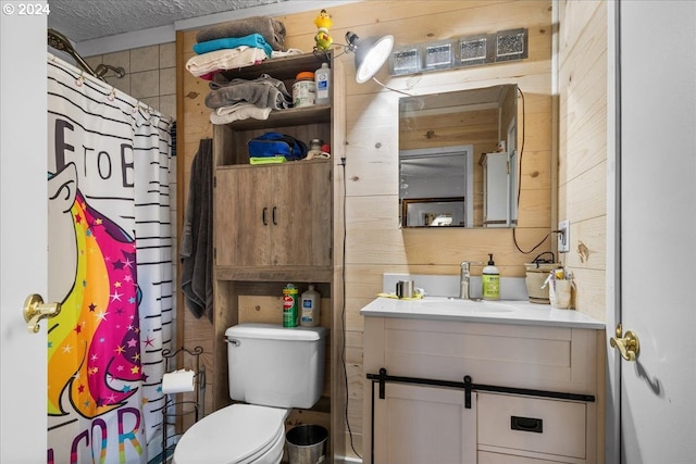 bathroom with toilet, a textured ceiling, wood walls, a shower with shower curtain, and vanity