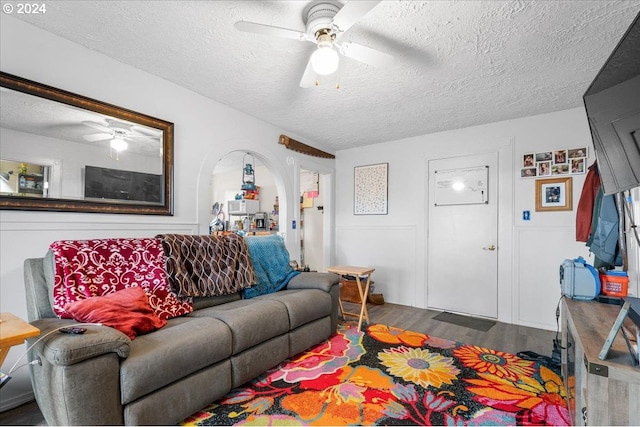 living room featuring a textured ceiling, dark hardwood / wood-style flooring, and ceiling fan