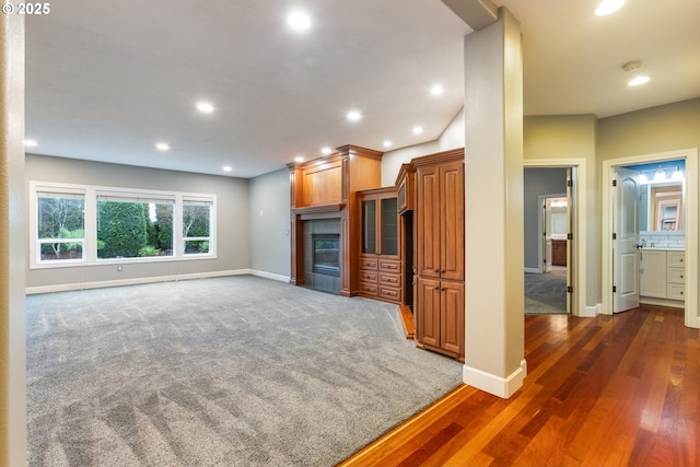 unfurnished living room featuring a fireplace and dark carpet