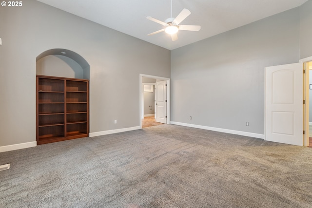 carpeted empty room featuring ceiling fan and high vaulted ceiling