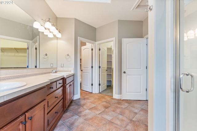 bathroom featuring vanity, a shower with shower door, and backsplash