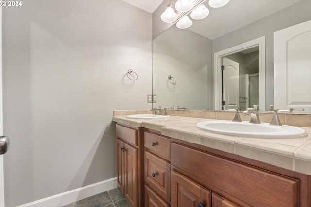 bathroom with tile patterned floors, vanity, and an inviting chandelier