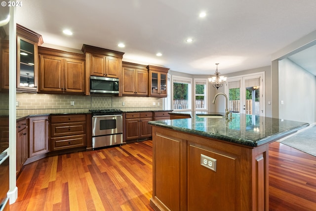 kitchen with an inviting chandelier, sink, dark hardwood / wood-style floors, an island with sink, and stainless steel appliances