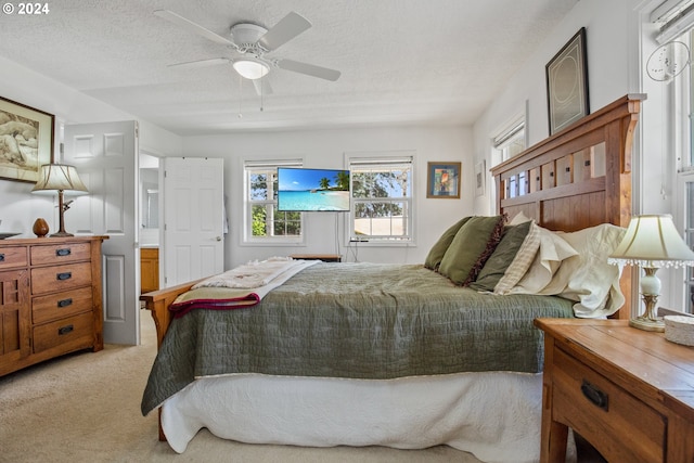 carpeted bedroom with ceiling fan and a textured ceiling