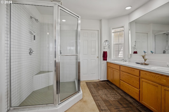 bathroom featuring vanity and a shower with door