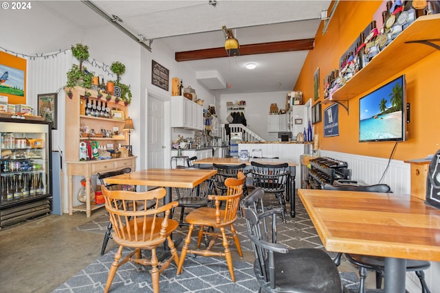 dining room with beamed ceiling and concrete floors