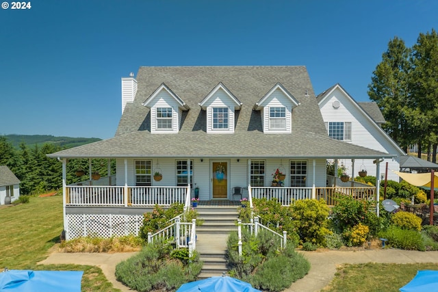 farmhouse-style home featuring a porch and a front yard