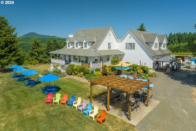 back of property featuring a gazebo, a mountain view, and a yard