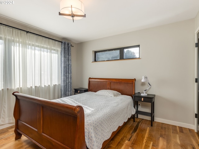 bedroom with hardwood / wood-style flooring and multiple windows