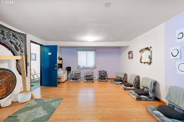 interior space with a textured ceiling and hardwood / wood-style floors