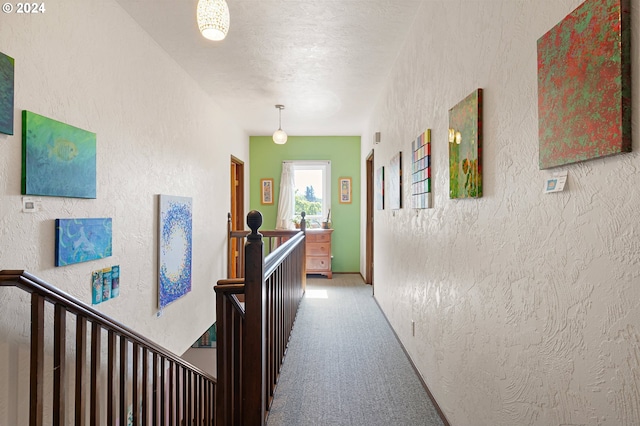 hall featuring a textured ceiling and carpet flooring