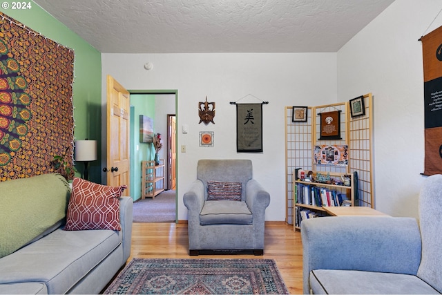 living room featuring light hardwood / wood-style flooring and a textured ceiling