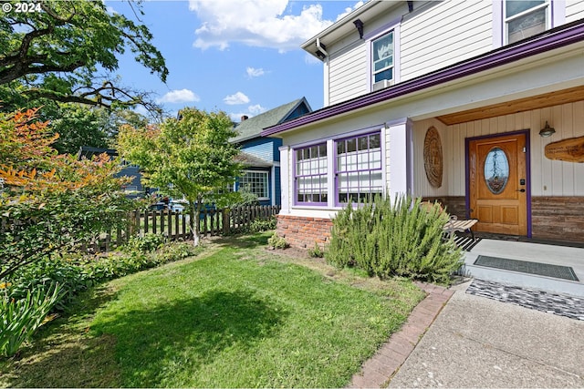 doorway to property featuring a lawn