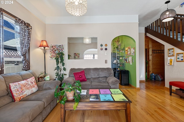 living room featuring a notable chandelier, cooling unit, and hardwood / wood-style flooring