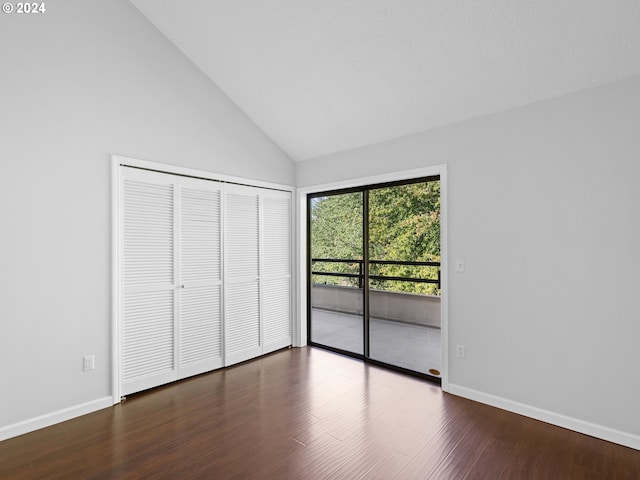 unfurnished bedroom featuring high vaulted ceiling, dark wood-type flooring, access to outside, and a closet