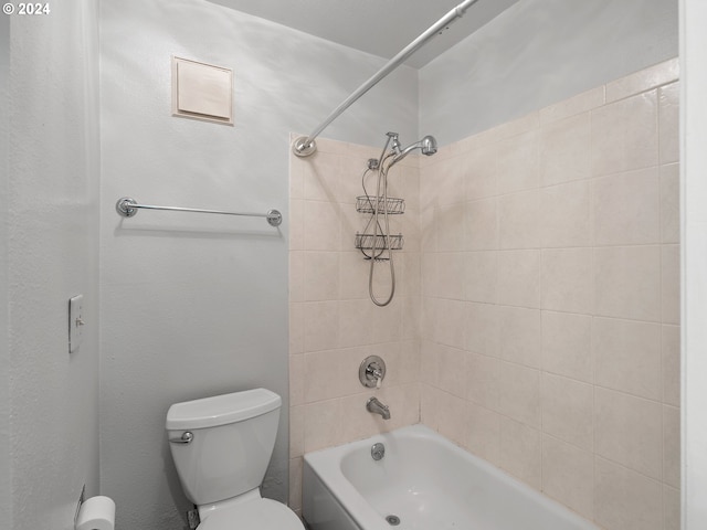 bathroom with tiled shower / bath combo and toilet