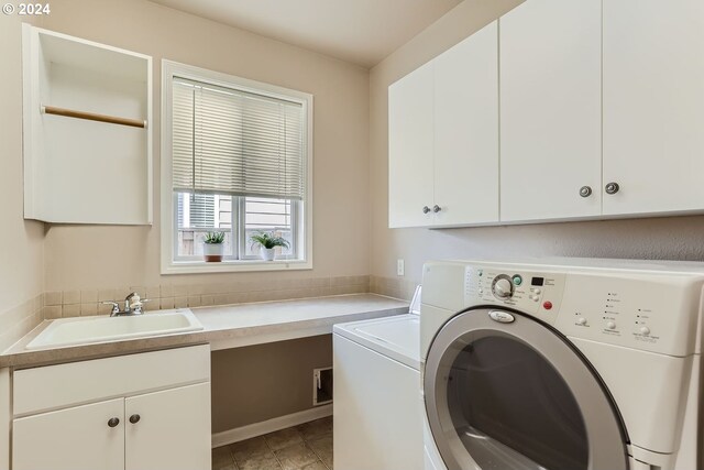 laundry room with washer and dryer, cabinets, and sink