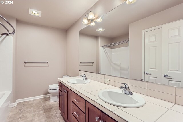 full bathroom with tasteful backsplash, tile patterned flooring, tub / shower combination, toilet, and vanity