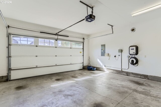 garage with electric panel and a garage door opener