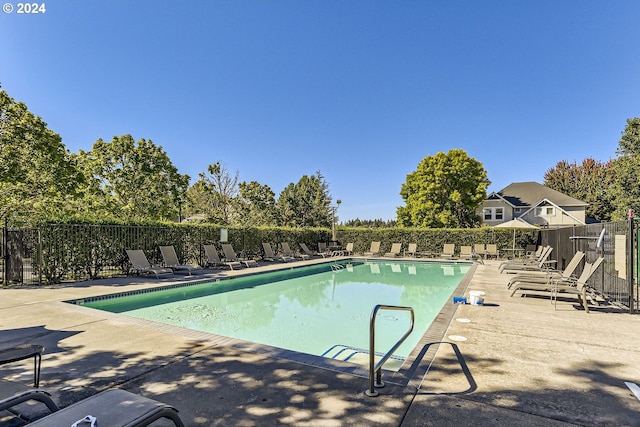 community pool featuring fence and a patio