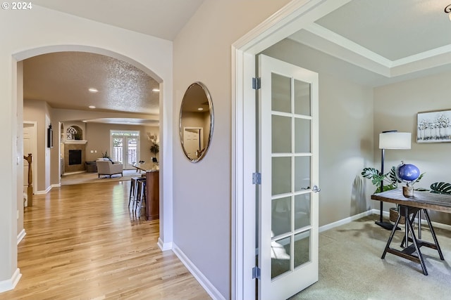 office area with french doors, a textured ceiling, and light hardwood / wood-style flooring