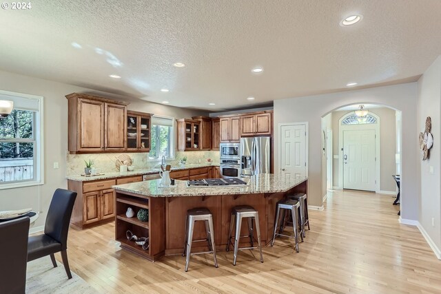 kitchen featuring appliances with stainless steel finishes, a kitchen island, and a wealth of natural light