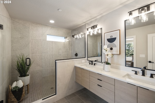 bathroom with tile flooring, double vanity, tile walls, and a shower with shower door