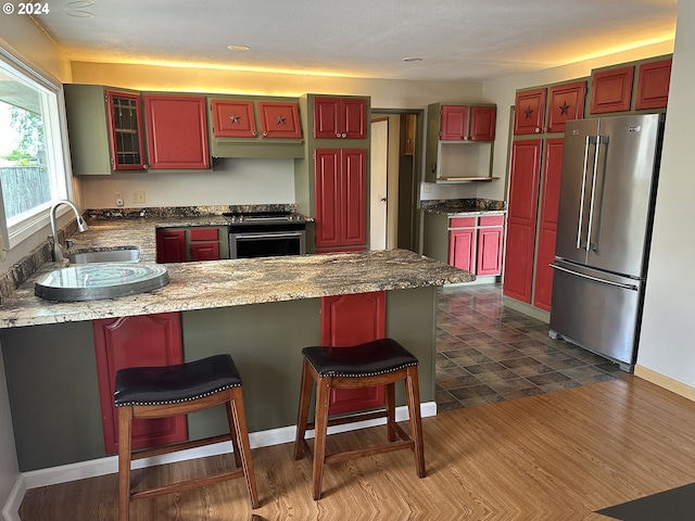 kitchen with stainless steel appliances, a kitchen bar, sink, and a center island