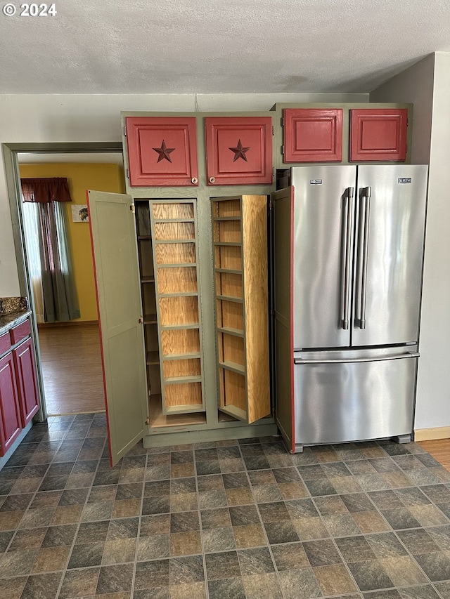 kitchen featuring a textured ceiling and high end fridge