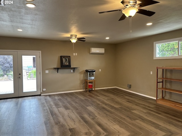 interior space featuring dark hardwood / wood-style flooring, a wall mounted AC, french doors, and a wealth of natural light