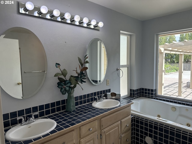 bathroom featuring tiled tub and vanity